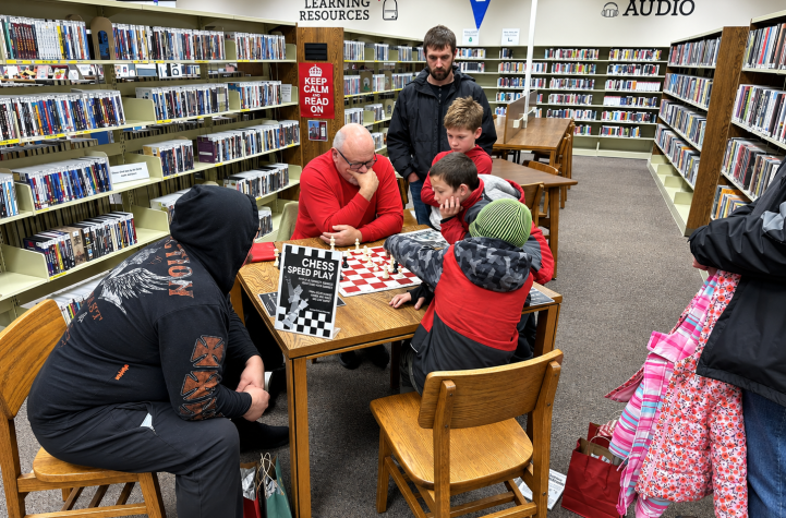 Group of kids learning chess from Mentor Sam
